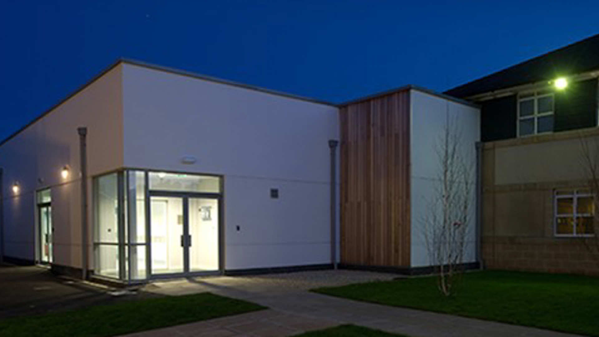 The small animal referral hospital building and nearby trees at night