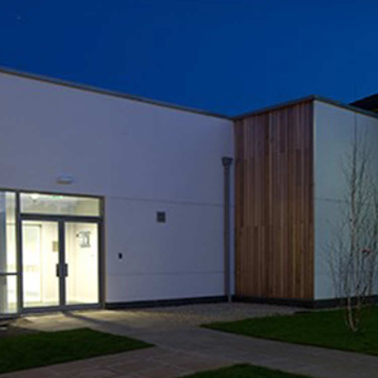The small animal referral hospital building and nearby trees at night